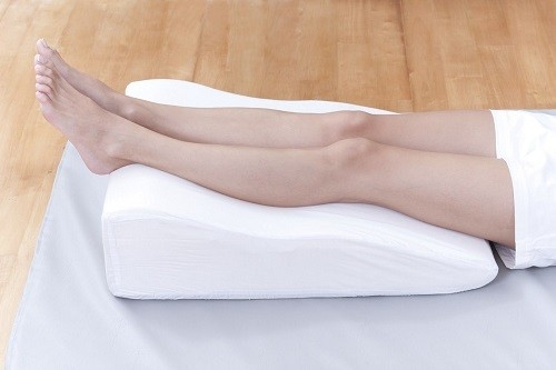 Tốt nhất nên nằm xuống nghỉ ngơi và kê cao chân bằng gối mềm. 
