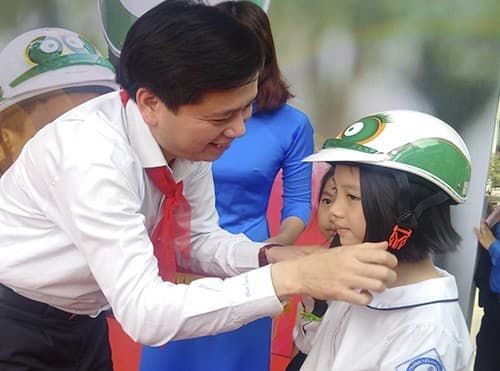 Đồng chí Nguyễn Long Hải - Bí thư Trung ương Đoàn, Chủ tịch Hội đồng Đội Trung ương tặng mũ bảo hiểm cho các em học sinh tại chương trình
