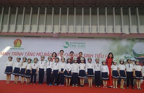 Ban tổ chức trao tặng mũ cho các em học sinh tại chương trình