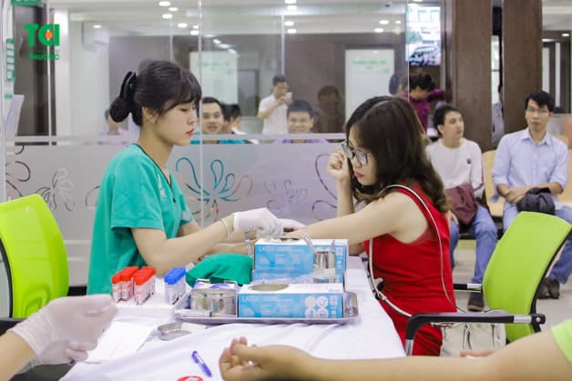 Lần lượt từng người được lấy máu để xét nghiệm