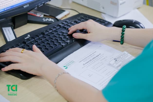 Bác sĩ kiểm tra hồ sơ sức khỏe của từng người để tổng hợp, cập nhật kết quả nhanh chóng.