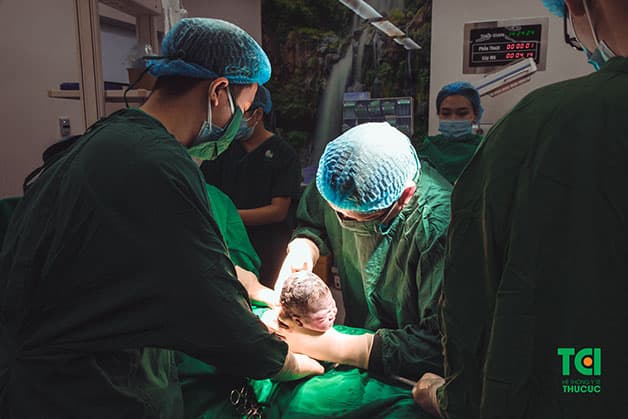Bác sĩ Nguyễn Văn Hà tiến hành đưa em bé ra ngoài một cách khéo léo