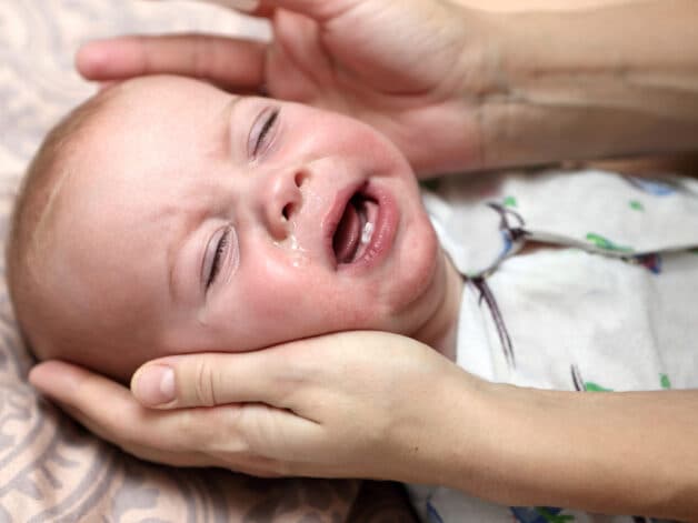 Mệt mỏi, quấy khóc là biểu hiện viêm phế quản ở trẻ nhỏ.