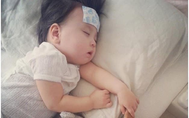 Chườm trán cho con để giảm sốt sau tiêm