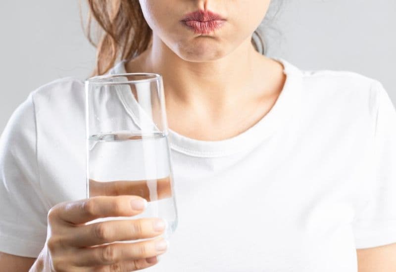 Dùng nước muối sinh lý hoặc súc miệng không cồn để diệt khuẩn, ngừa hôi miệng sau trồng răng giả.