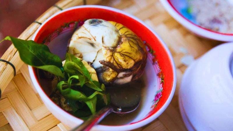 Trứng vịt lộn trong chén ăn kèm rau răm, liên quan lượng calo của trứng vịt lộn.