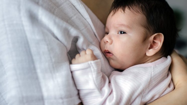 Bố mẹ nên nới lỏng quần áo của con, chườm ấm vào cổ, nách, bẹn để giúp con hạ sốt