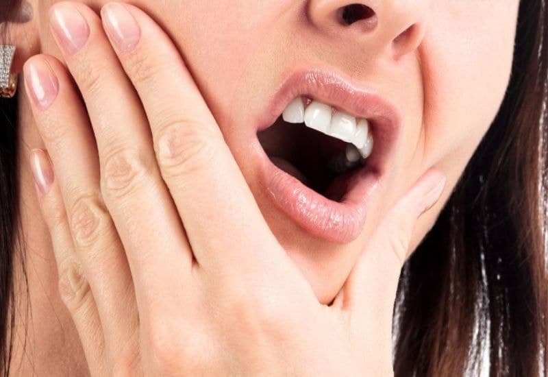 Mọc răng số 8 bị đau nhức hoặc ê buốt răng ở vùng cuối hàm.