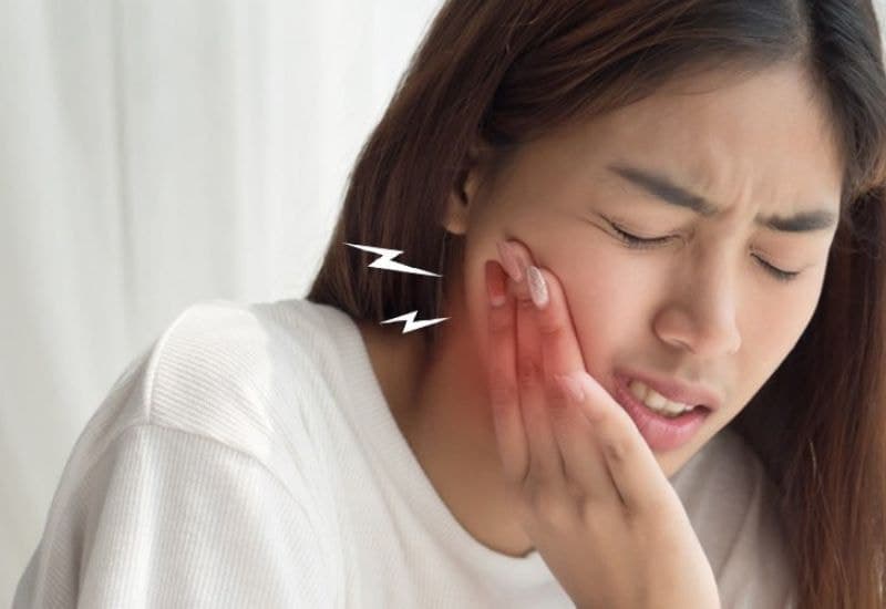 Đau nhói khi tiếp xúc với đồ nóng, lạnh; cảm giác ê buốt khi ăn đồ chua, ngọt là triệu chứng của tẩy trắng răng bị buốt.