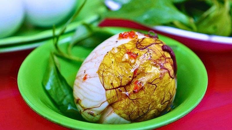 Trứng vịt lộn đã bóc vỏ đặt trong chén nhỏ, liên quan lượng calo cao của trứng vịt lộn.