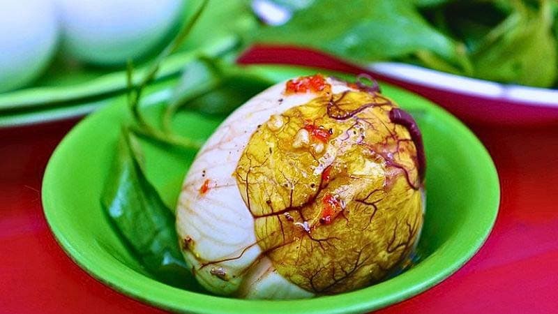 Trứng vịt lộn đã bóc vỏ đặt trong chén nhỏ, liên quan lượng calo cao của trứng vịt lộn.