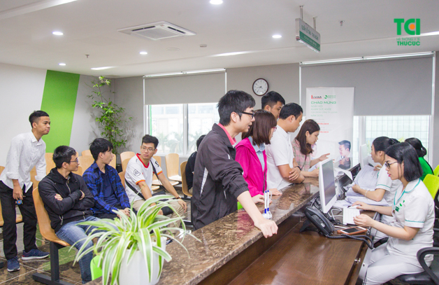 Mọi người làm thủ tục tại quầy lễ tân để tiến hành khám sức khỏe doanh nghiệp định kì nhanh chóng