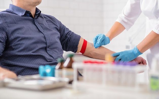 bác sĩ lấy máu cho người bệnh