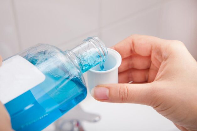 Súc miệng bằng nước súc miệng kháng khuẩn để khắc phục tình trạng viêm lợi bị hôi miệng.