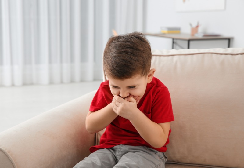 Trẻ có thể khó chịu ở vùng bụng trên và tiết nhiều nước bọt, đây là dấu hiệu sớm của buồn nôn.